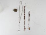 rosary, cross, and stone on a white surface with a bottle of water