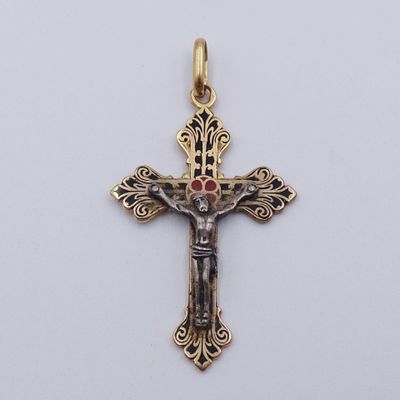 une croix en or ornée d'une pierre rouge