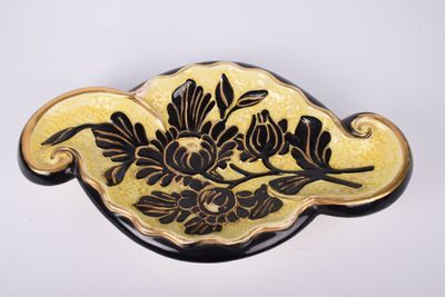 une broche noire et jaune ornée de fleurs