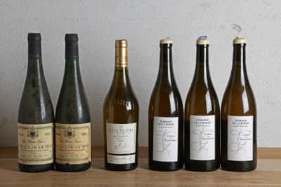 plusieurs bouteilles de vin sont alignées sur une table en bois