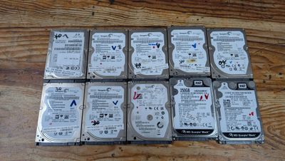 six disques durs empilés les uns sur les autres sur une table en bois
