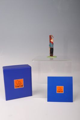 une petite figurine posée sur une boîte bleue