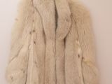 une photo d'un manteau de fourrure blanche accroché à un mur