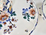 a close up of a plate with flowers and birds on it