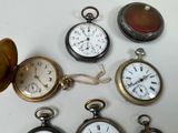 many different types of pocket watches on the table