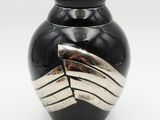 un vase noir orné de rayures argentées sur fond blanc