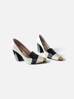 une paire d'escarpins noirs et blancs ornés d'un nœud au talon