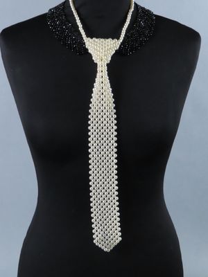 un gros plan sur un mannequin portant une cravate blanche ornée de perles