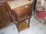 une armoire en bois avec un plateau en marbre, à côté d'une boîte en carton