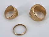 two gold rings and a gold ring on a white surface