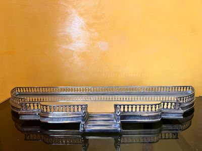 une table en verre sur laquelle est posé un plateau en métal