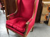 une chaise rouge aux finitions dorées et à la structure en bois