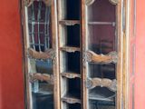an old wooden cabinet with glass doors in a room