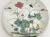 une assiette sur laquelle est représenté un tableau représentant des fleurs et un oiseau