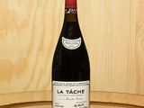 une bouteille de vin posée sur un tonneau en bois