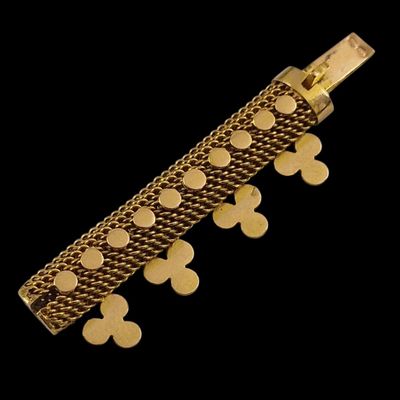 bracelet en métal plaqué or orné de pièces de monnaie, sur fond noir