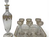 a silver tray with six wine glasses and a glass decanter