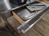 an open drawer that has a pan and a knife in it