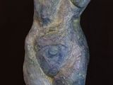 a close up of a sculpture of a woman on a wooden stand