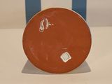 a brown plate with a blue and white stripe in the background