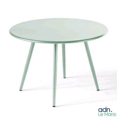 La table est verte ; elle a trois pieds et un plateau rond.
