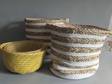 three woven baskets sitting on top of a table next to a yellow bowl