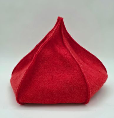 un gros plan d'un chapeau rouge posé sur une surface blanche