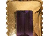 an image of a gold pendant with a purple stone in it