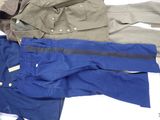 three pairs of pants and a jacket on a bed