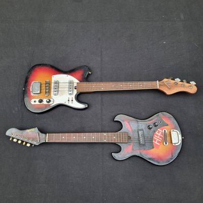 deux guitares électriques posées côte à côte sur une surface noire