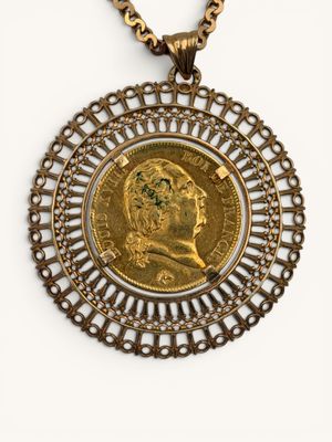 a close up of a gold coin with a chain around it