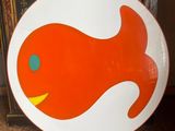 a plate with a fish design on it sitting on the floor