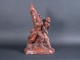 statue of a man holding a sword on a gray background