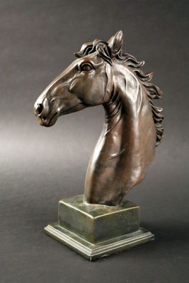 statue représentant une tête de cheval sur un socle, sur fond gris