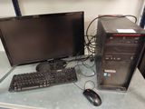 un ordinateur de bureau posé sur une table à côté d'un clavier et d'une souris