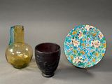 two vases and a plate sitting next to each other