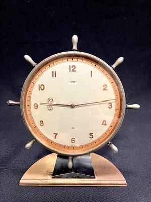 a clock that is sitting on a stand on a table