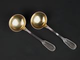 a pair of silver spoons on a black background