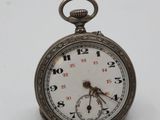 a silver pocket watch on a white surface