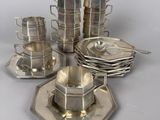 a silver plate with cups and saucers on it