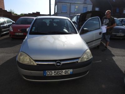 a man standing next to a silver car in a parking lot