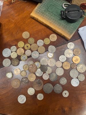 a lot of coins on the table next to a camera