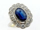 gros plan d'une bague avec une pierre bleue entourée de diamants