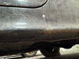 a close up of a car with a rusted bumper