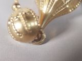 a gold ornament that is sitting on a white surface