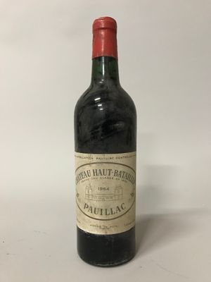 une vieille bouteille de vin posée sur une table blanche