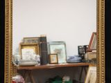 a mirror that is sitting on a shelf in a room