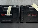Deux valises noires, munies d'étiquettes, sont posées sur une table