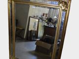 a mirror that is sitting on the floor in front of a chair