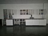 a white kitchen with a black counter top and white cabinets